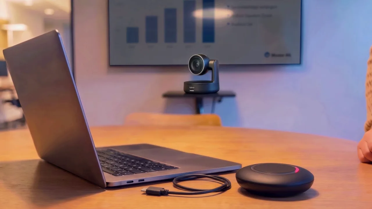 Besprechungstisch mit Laptop, Kamera und Konferenzlautsprecher